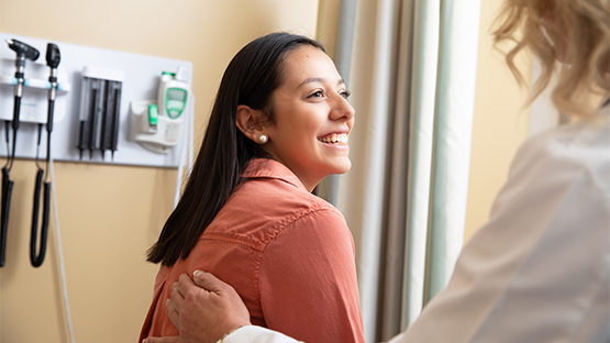 Woman smiling as she speaks with her doctor